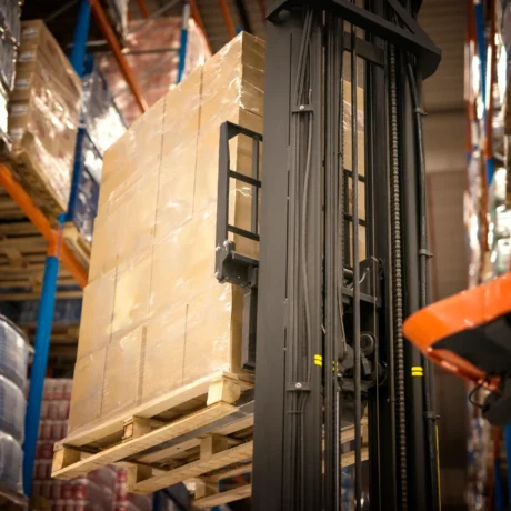 industrial forklift machine lifting palette full cardboard boxes placing them shelves distribution w